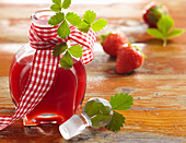 Homemade summer strawberry syrup in a small bottle with a ribbon
