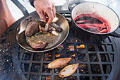 A winter barbecue: quails being grilled in a pan (Norway)