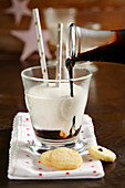 Homemade chocolate and coffee syrup being poured into hot vanilla milk