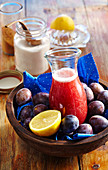 Homemade damson syrup in a jar in a wooden dish