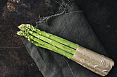 A bundle of green asparagus on a linen cloth