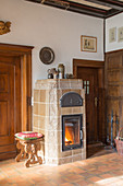 Fire burning in tiled stove between wooden doors