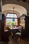 Wood-panelled seating area in sunny farmhouse parlour