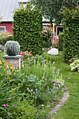 Garten mit Staudenbeet, gemauerter Säule und Hecke