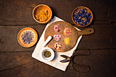 Various floral salts and dried flowers in bowls and on a wooden board