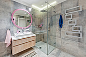 Designer heated towel rail in modern bathroom with pink accents