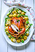 Baked chicken with young potatoes and asparagus on a large dish
