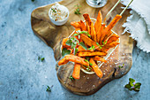 Spicy sweet potatoes fries with fresh herbs and salt flakes