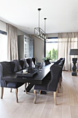 Elegant upholstered chairs around black table in dining area