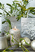 Advent-calendar bags, candle, mistletoe and baubles