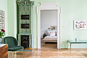 Tiled stove in living room with green walls