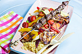 Chicken heart skewer on colourful roast vegetables with yellow lentils