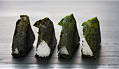 Vier Onigiri im Noriblatt gefüllt mit Umeboshi (Japan)