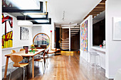 Abstract mural in an open living room with dining table, breakfast bar and spiral staircase