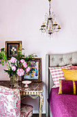 Bedroom in a mix of styles with a Toile de Jouy armchair and Rococo table next to an upholstered bed