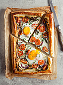 Puff pastry breakfast tart with eggs and tomatoes