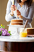 Frau beim Zubereiten einer mehrschichtigen Torte