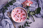 Bowl of yogurt with raspberry powder and dried rose buds