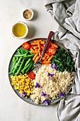 Veganer Couscoussalat mit Mais, Bohnen, Babykarotten und Spinat