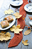 Rusty-red leaf-shaped hand-knitted coasters for decorating autumnal table