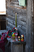 Hand-painted glass candlestick and traditional Russian dolls on wooden bench