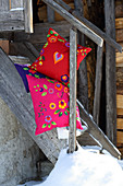 Colourful cushions decorated with ethnic felt flowers and felt hearts