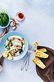 Turkish eggs with a butter sauce accompanied by spinach, red pepper flakes and toasted bread