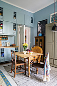 Küche im Boho-Stil mit hellblauen Schränken und rustikalem Holz-Esstisch