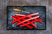 Rhabarberstangen mit Vintage-Messer auf Ofenblech