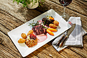 Pollak sauerbraten with red wine sauce, vegetables and croquettes