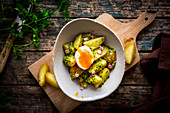 Potatoes with herb pesto, onion and an egg