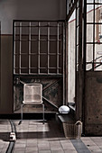 Filigraner Stuhl vor einer alten Fabriktür aus Metall
