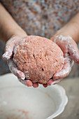 Hands holding dough for beetroot gnocchi