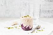 Chia pudding with blueberry compote and pistachios in a glass