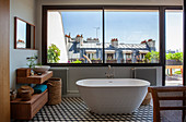 Bad mit breiter Fensterfront, freistehender Badewanne und Hexagon-Fliesenboden