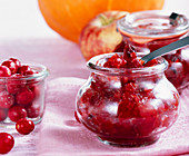 Pumpkin and cranberry chutney in mason jars on a napkin