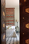 View through old wooden door into Oriental bedroom
