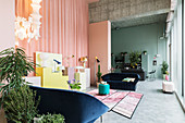 Offener Wohnraum mit pastellfarbenen Wänden und Sichtbetondecke