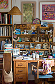 Regal mit Ethno-Accessoires überm Schreibtisch in Künstlerwohnung
