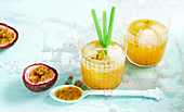 Encanto Tropical - cocktails with passion fruit, almond liqueur, ice and straws