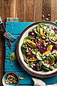 Spinach salad with beets, italian nuts, feta cheese, oranges and mustard vinaigrette sauce