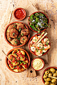 Various tapas - patatas bravas, croquetas with serrano ham, fried padron peppers, shrimps with garlic (Spain)