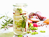 Babybel cheese pickled in oil with fresh herbs, jalapenos, pink pepper and bay leaves