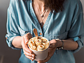 Vanilla rolled ice cream in cone cup in woman hands