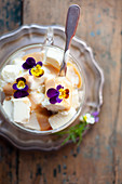 Vanilla ice cream with caramel sauce and viola flowers