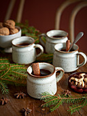 Rustic cups of mulled wine with cinnamon sticks