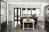 Dining area and industrial-style glass sliding door as partition in open-plan kitchen