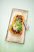 Butternut squash filled with minced meat and black beans on a tray