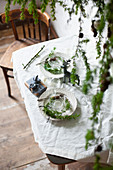 Place settings decorated with larch twig on table set for Christmas meal
