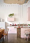 Open-plan kitchen in shades of pink with Christmas decorations